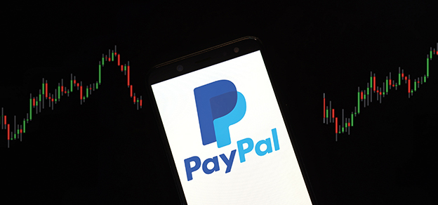 A mobile device featuring the PayPal logo with candlestick charts in the background, highlighting the intersection of finance and technology.