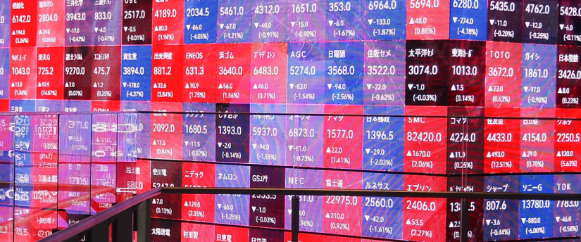 A man is positioned in front of a colorful display of stock market information and data.