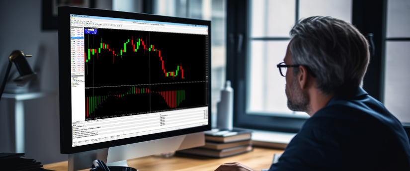 A focused man examines a computer screen featuring a trading indicator, engaged in financial analysis.