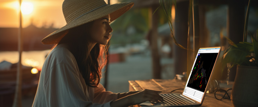 Uma mulher de chapéu está concentrada em seu laptop, focada na tela.