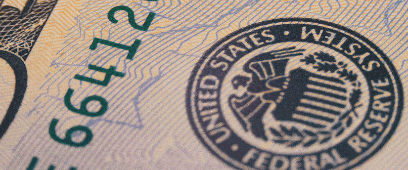 Detailed close-up of a United States dollar bill showing the official Federal Reserve System seal and green serial numbers, representing Federal Reserve Rate Cut Expectations 2026.