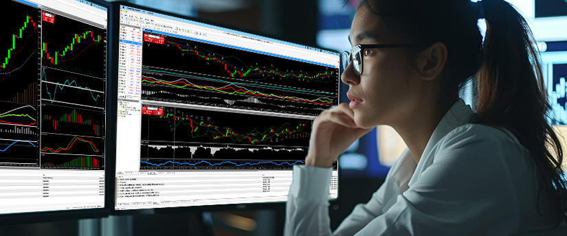 A female trader wearing glasses focuses intently on multiple monitors displaying complex technical charts, analyzing market trends to find high paying trades in forex.